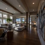 Open living room with Agreeable Gray walls, white ceilings, and white-trimmed windows, looking through to the dining room in a new Spearfish, SD home.