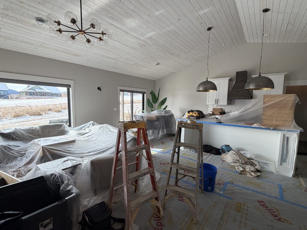 Professional interior painting project with furniture carefully covered and protected before painting inside a custom home in the Black Hills, South Dakota.