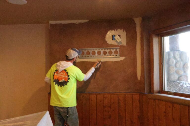 Black Mountain Painting technician skim-coating drywall repair with corner bead before repainting an interior wall