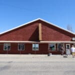 Freshly repainted red log-sided commercial building in Buffalo SD completed by Black Mountain Painting.