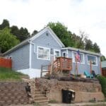 Freshly repainted home in Deadwood SD with new light blue exterior and white trim by Black Mountain Painting.