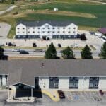 Quality Inn in Spearfish SD after exterior repainting by Black Mountain Painting with refreshed tan and green finish.
