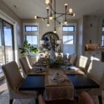 Dining room with Sherwin-Williams Agreeable Gray walls and white-trimmed windows opening to the kitchen in a new Spearfish, SD home.