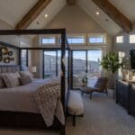 Primary bedroom with a vaulted white shiplap ceiling, stained wood beams, and Agreeable Gray walls in a new Spearfish, SD home.