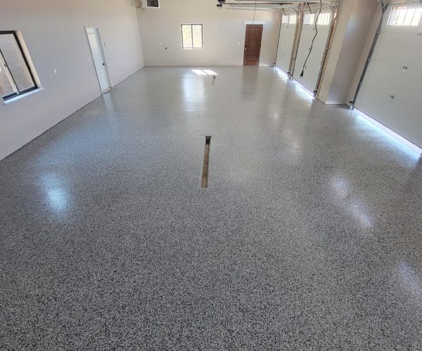 Custom epoxy garage floor installed by Black Mountain Painting in Spearfish, SD, featuring a durable, seamless flake finish in a clean, spacious residential garage.